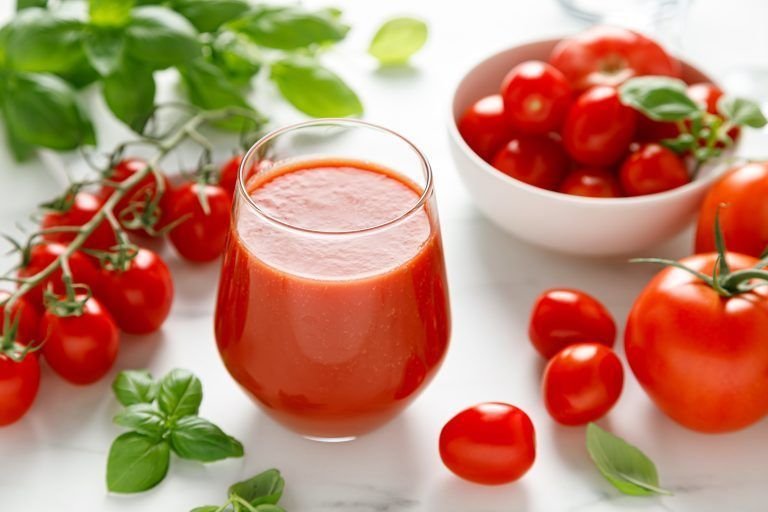 Tomato juice in a glass and fresh tomatoes